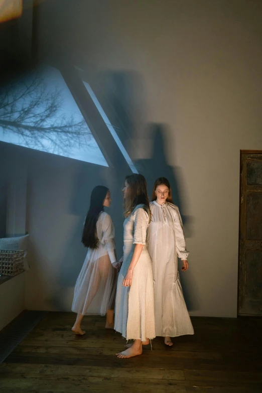 three girls are standing in the shadows of a large shadow