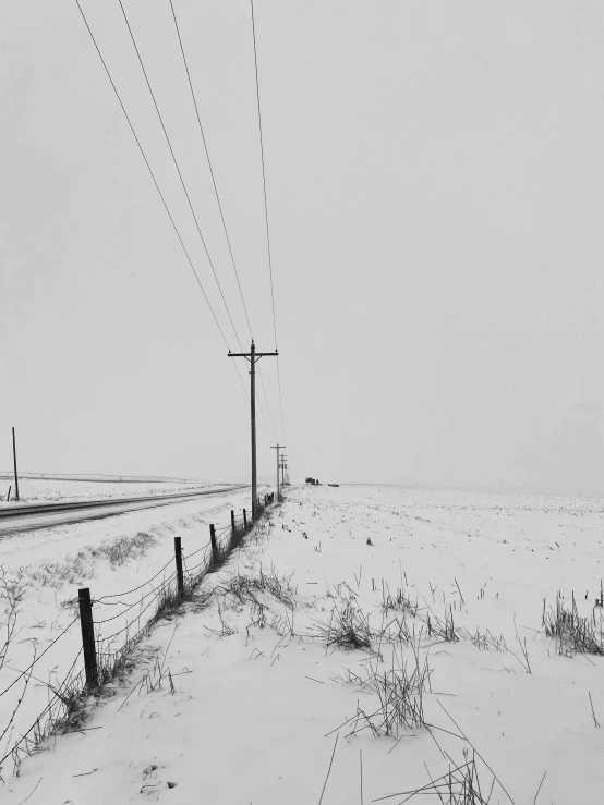 the telephone pole stands in the snowy landscape