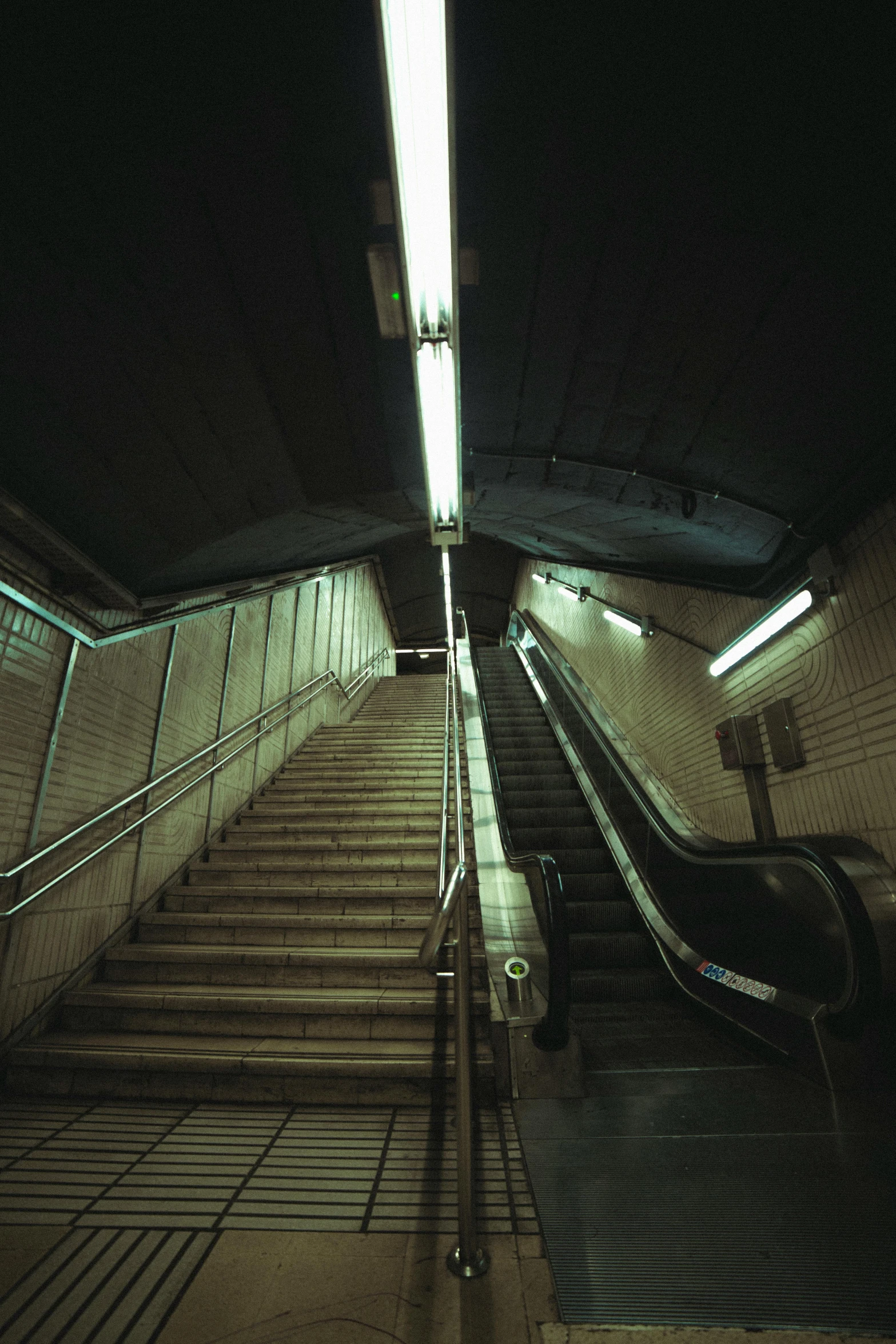 a very dark looking stairway with a clock on it