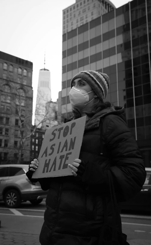 a person with a mask holding a sign