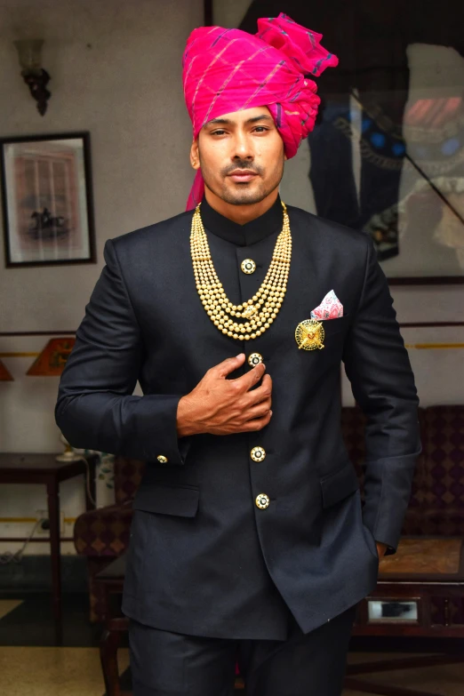 a man in an indian costume standing with an ornate necklace