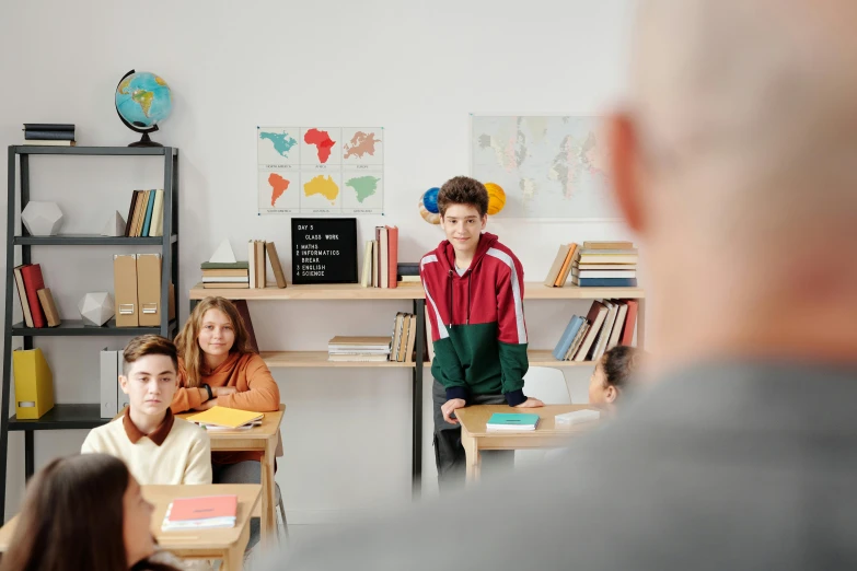 children are sitting in the school room with adults