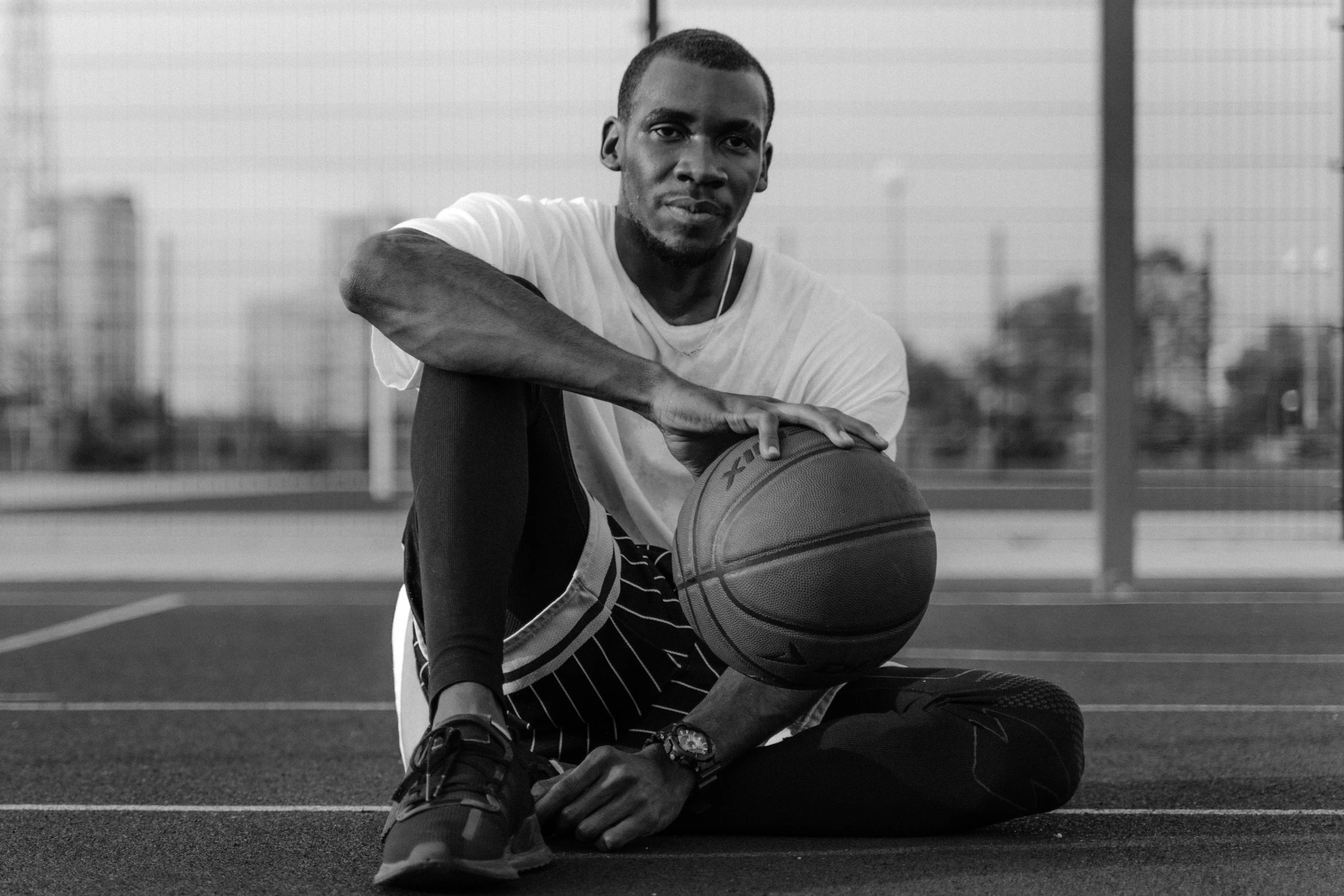 a man sitting on the floor with a basketball