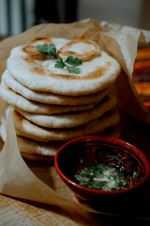 some flat breads are on a table and one is a bowl