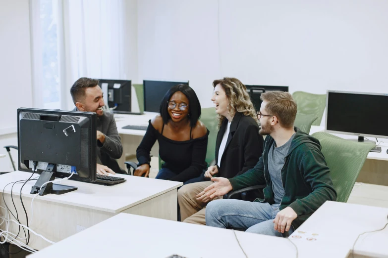 a group of people gathered around a computer monitor