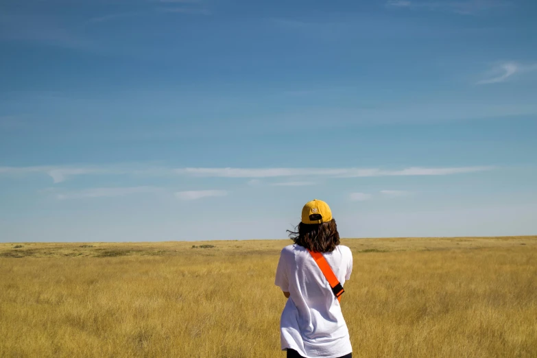 a man standing in a grassy field flying a kite