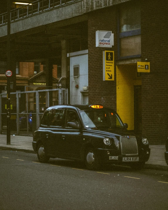 a car parked outside of an establishment under a bridge