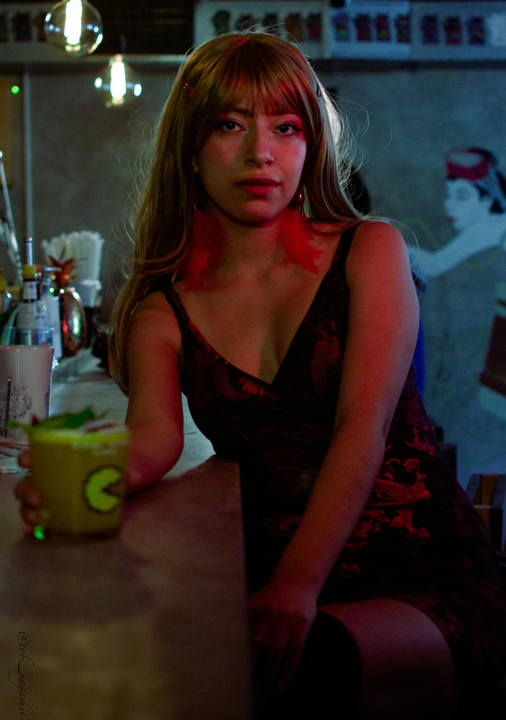 a woman sitting at a bar with a cup