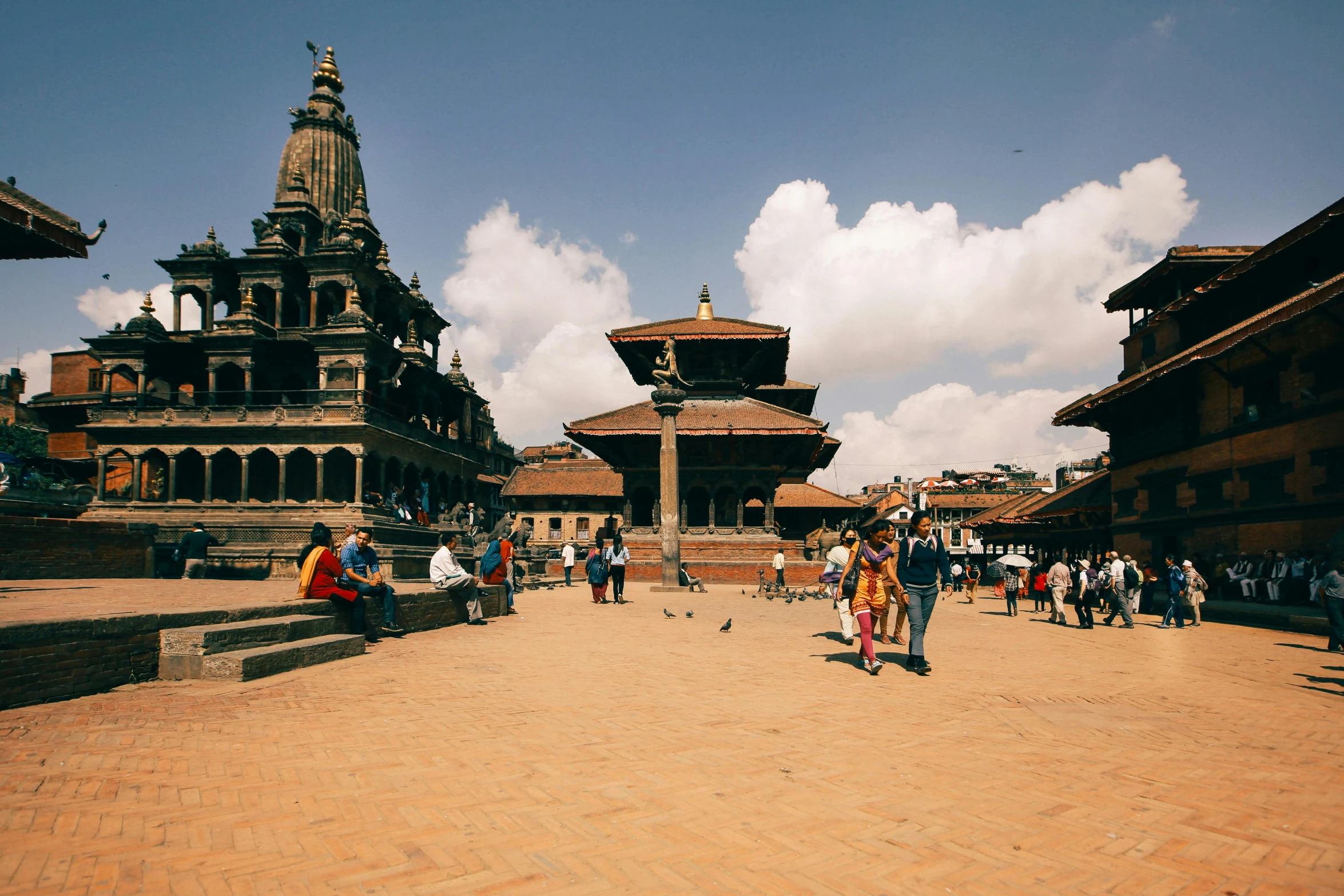 several people are walking in a brick courtyard