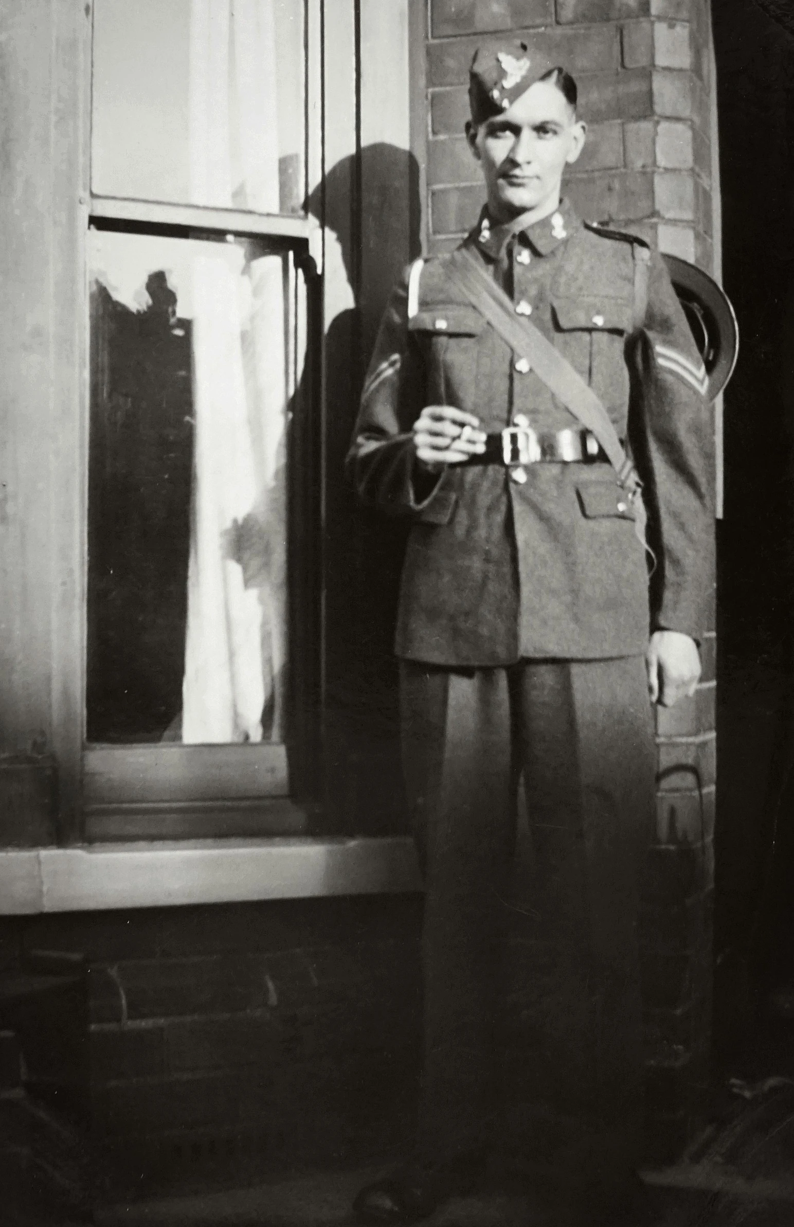 a man standing next to a brick wall