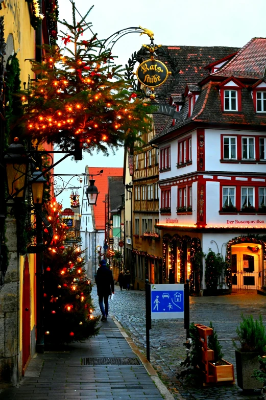 a narrow street in germany decorated with christmas decorations