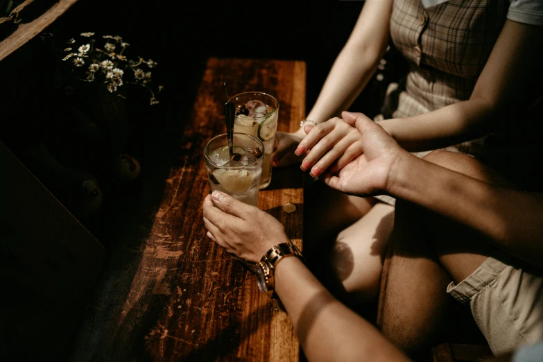 two people with a cocktail on a wooden table