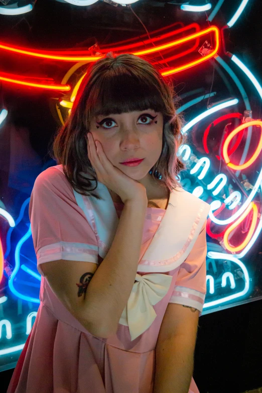 a young woman poses with her hand on her face