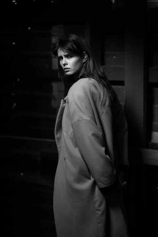black and white pograph of a woman in an oversize coat