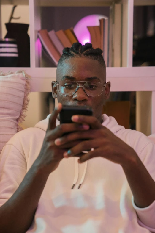 a man sitting down while looking at a cell phone