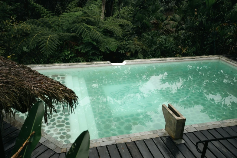 a pool with a bench sitting at the edge