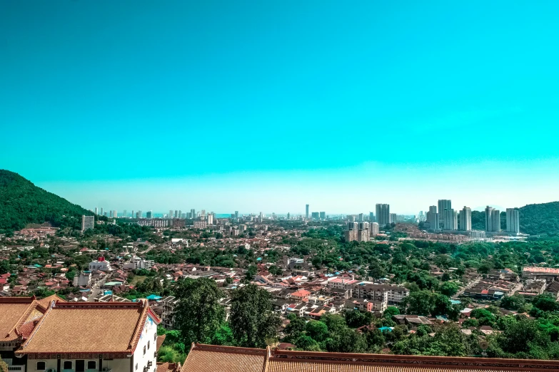 a city with lots of trees, buildings and mountains