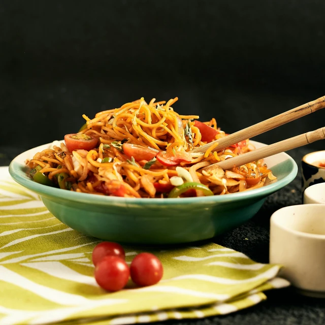 a bowl of noodles with tomato and herbs