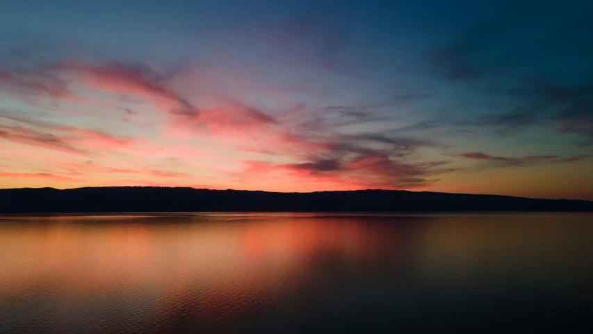 a large body of water that is under a cloudy sky