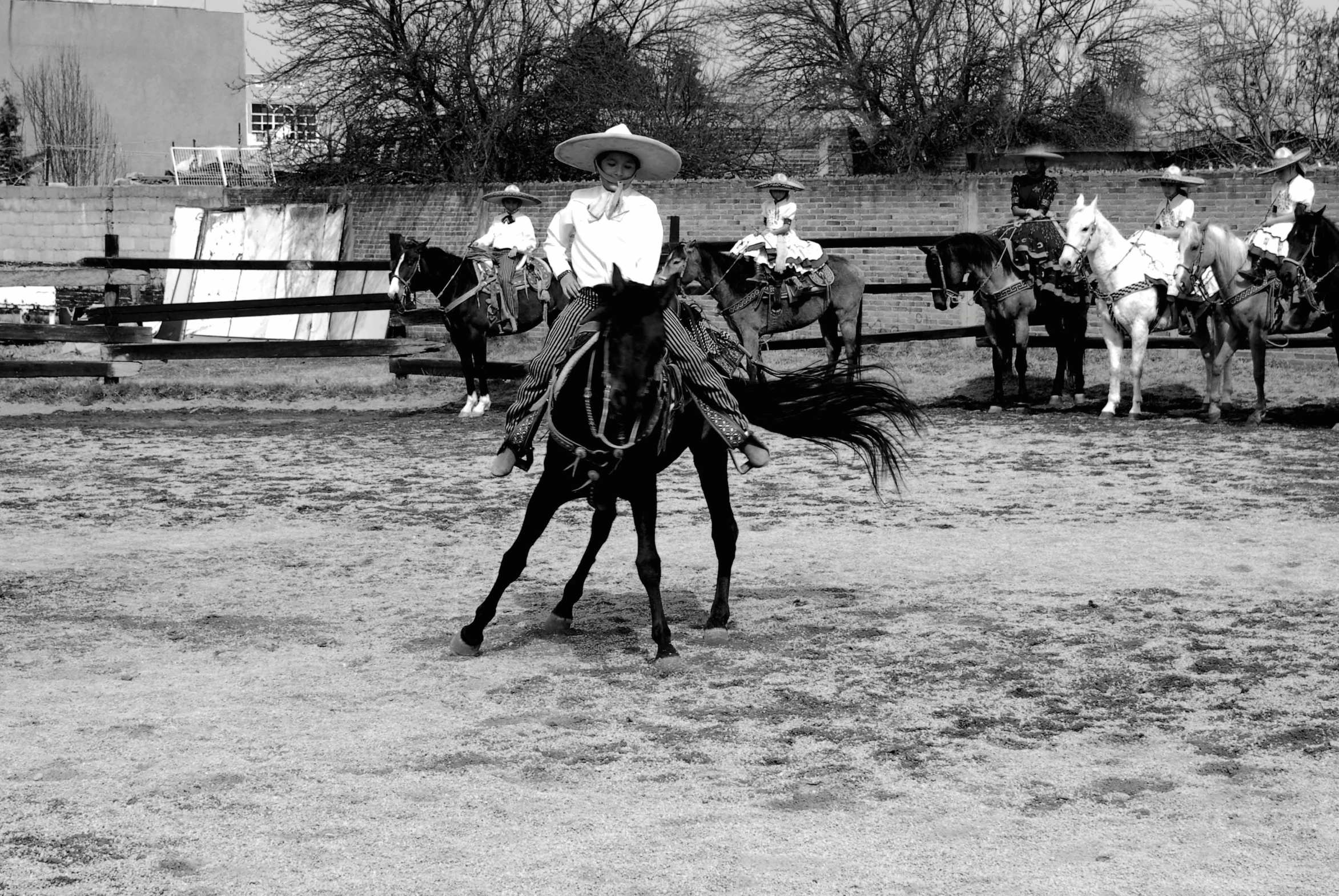 a man in a western suit riding on the back of a horse