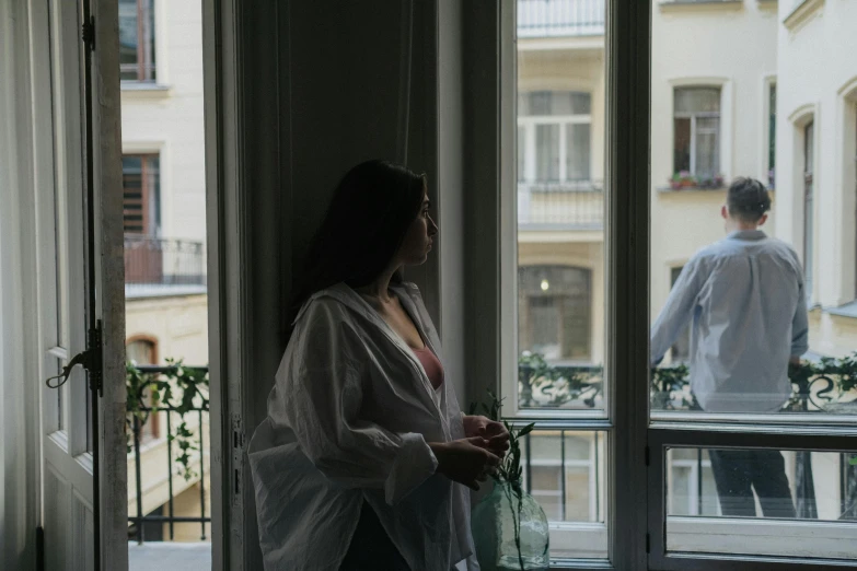 a woman standing next to a window in a living room