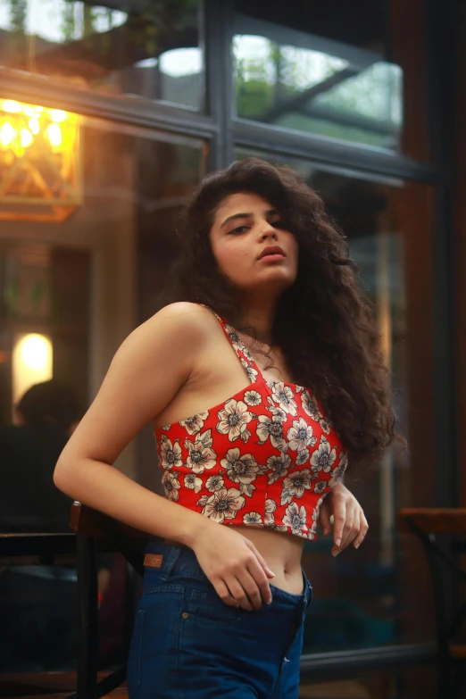 a beautiful young lady with long hair standing next to a window