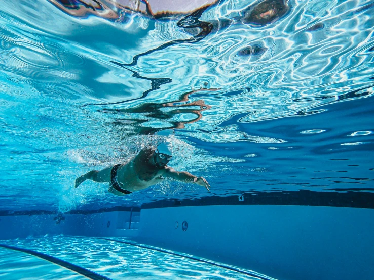 the underwater side view shows the clear water, with the body of water as well as a swimmer and a boat