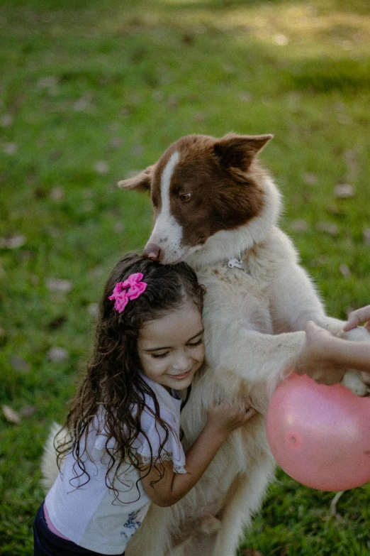 a dog holding a girl over it's face