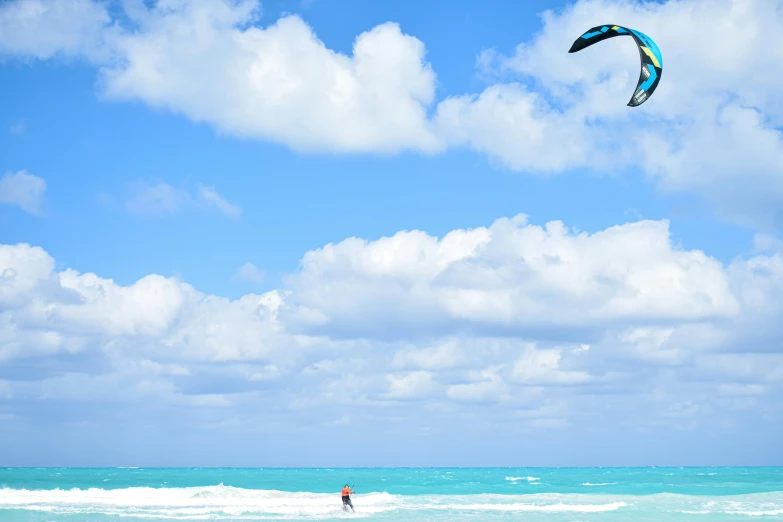 someone is parasailing in the water while standing in the waves