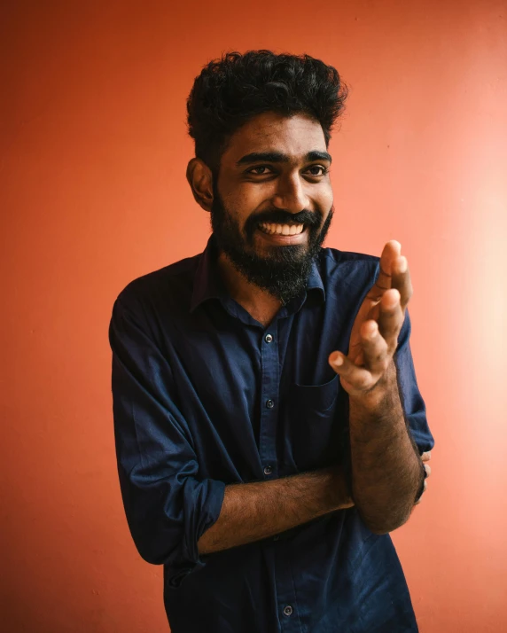 a man with his hands crossed in a smiling pose