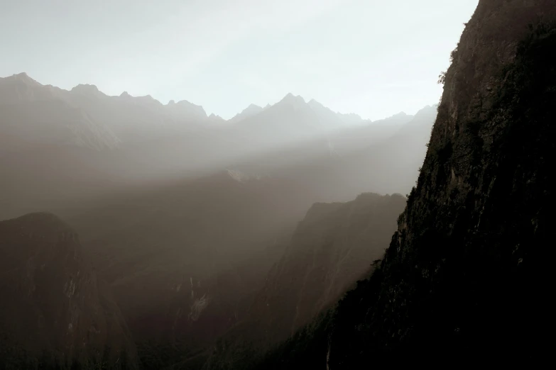 a black and white po of a mountain with the sun shining down on mountains