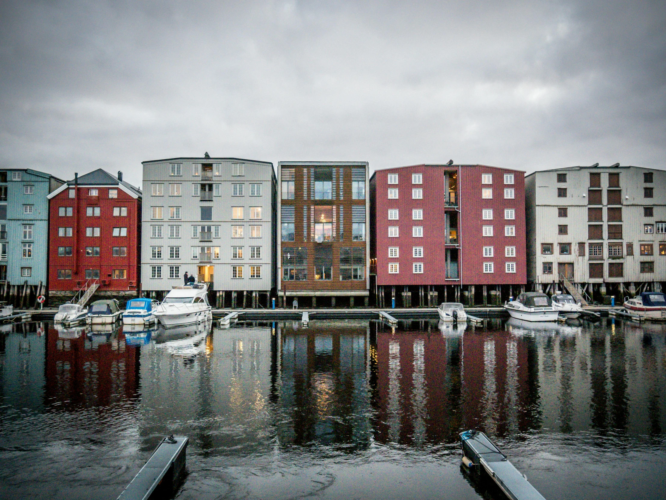 boats in a harbor near large multi - story buildings