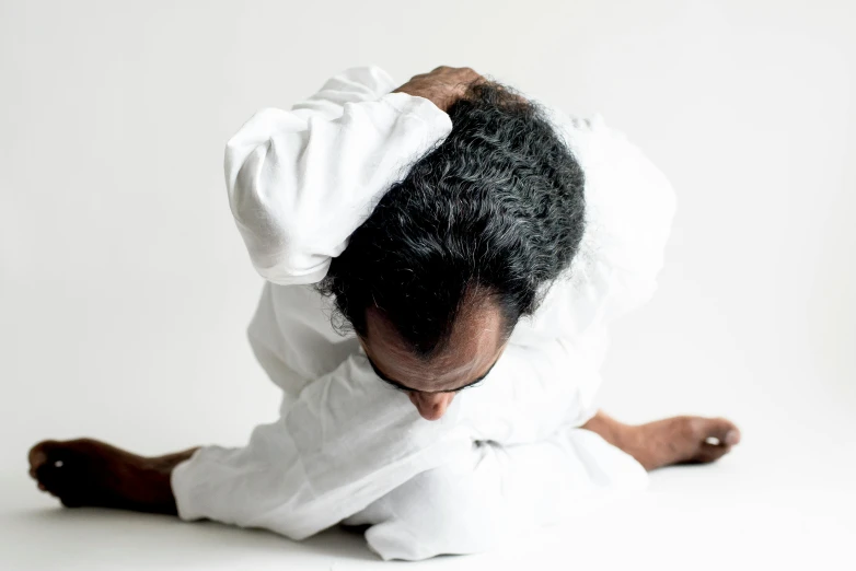 an animal in a white outfit laying down on the ground