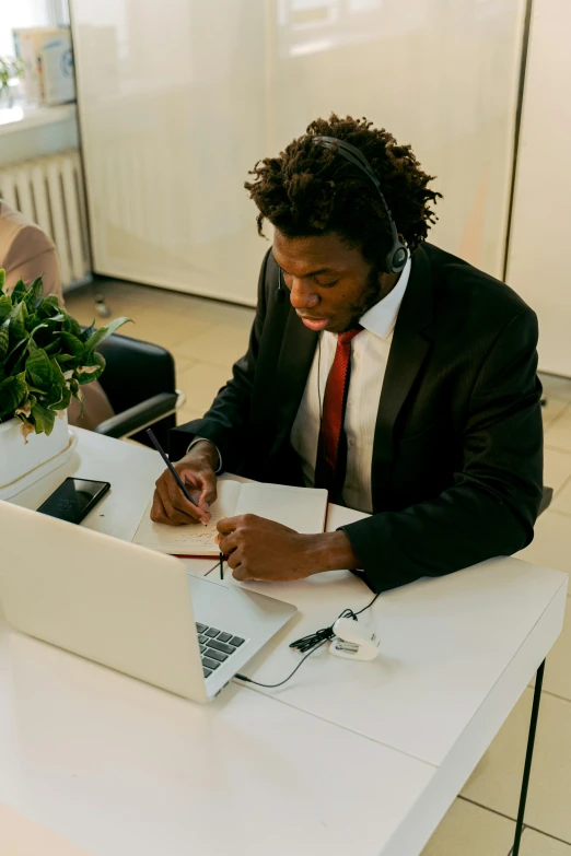 a person in a suit working at a desk on a laptop