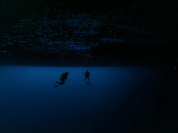 a couple of people diving out into the water