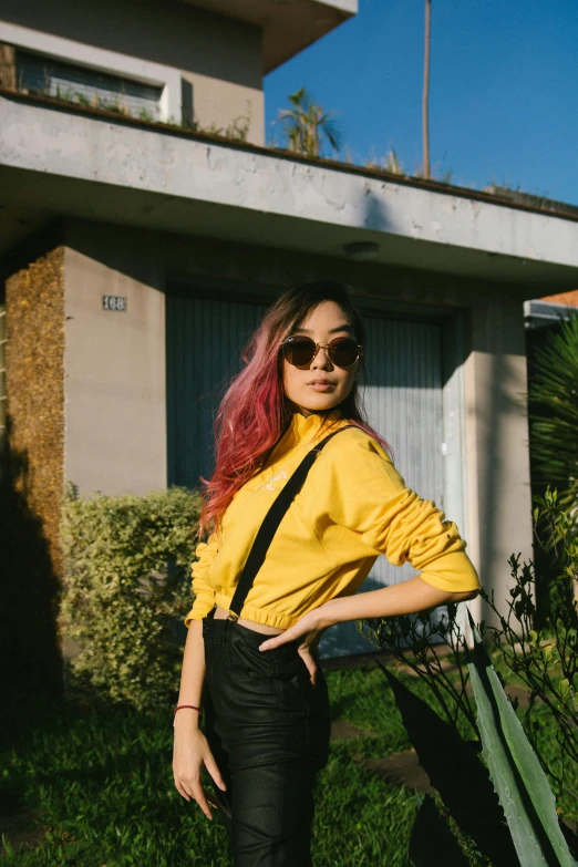 a woman posing for the camera in front of a house