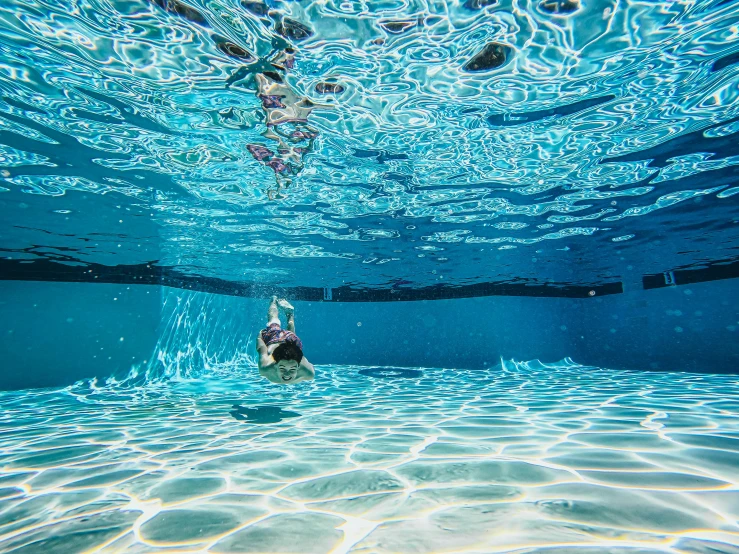 a woman is swimming in clear blue water