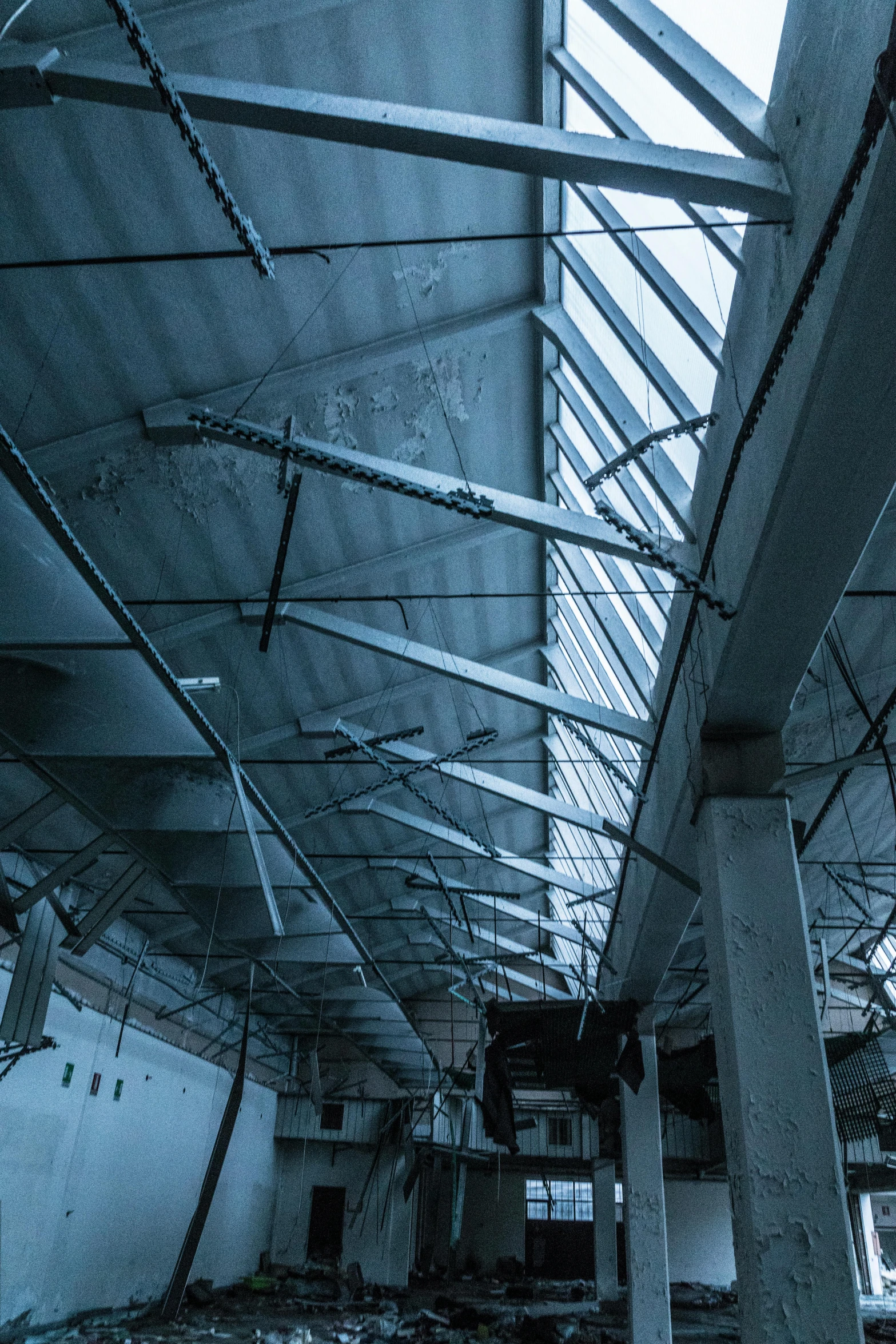 the inside of an abandoned building and its roof is partially destroyed