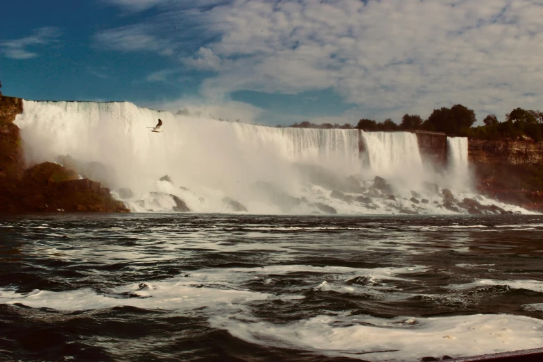 a man is kite surfing in front of the waterfall