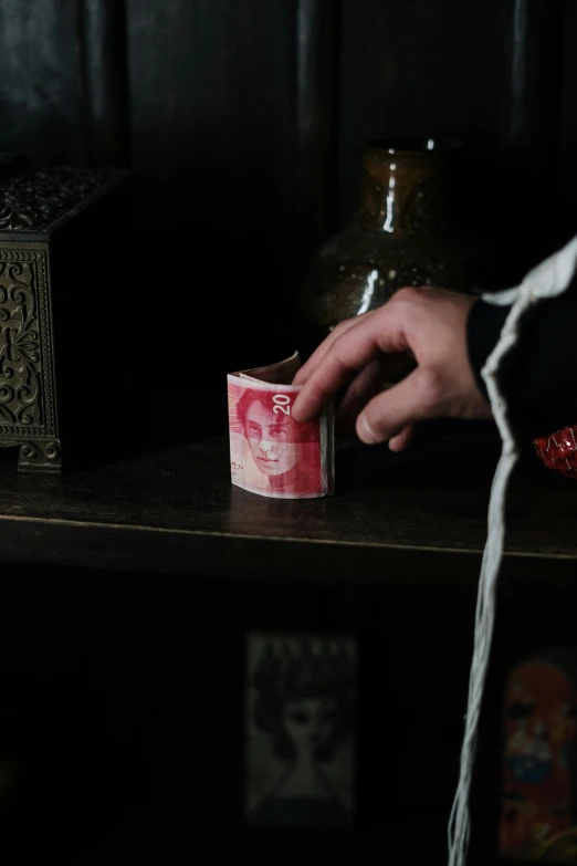 a person is holding a candle in front of a vase