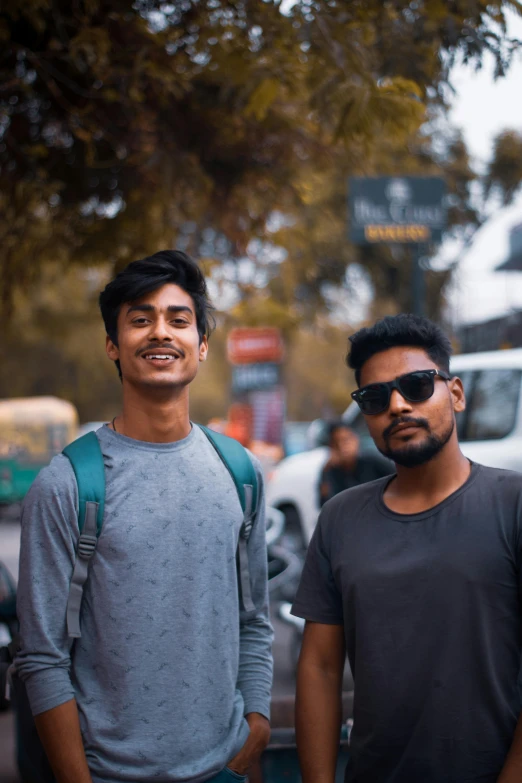 two young men standing on the sidewalk near a truck