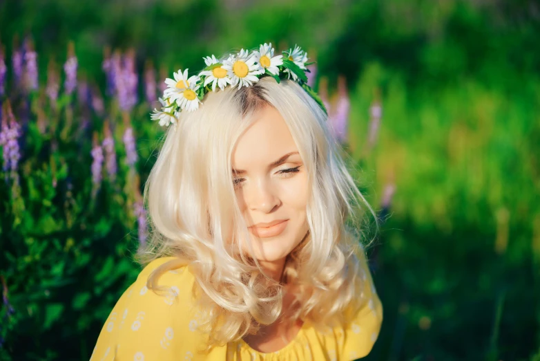 a blonde girl in yellow shirt with daisies on head