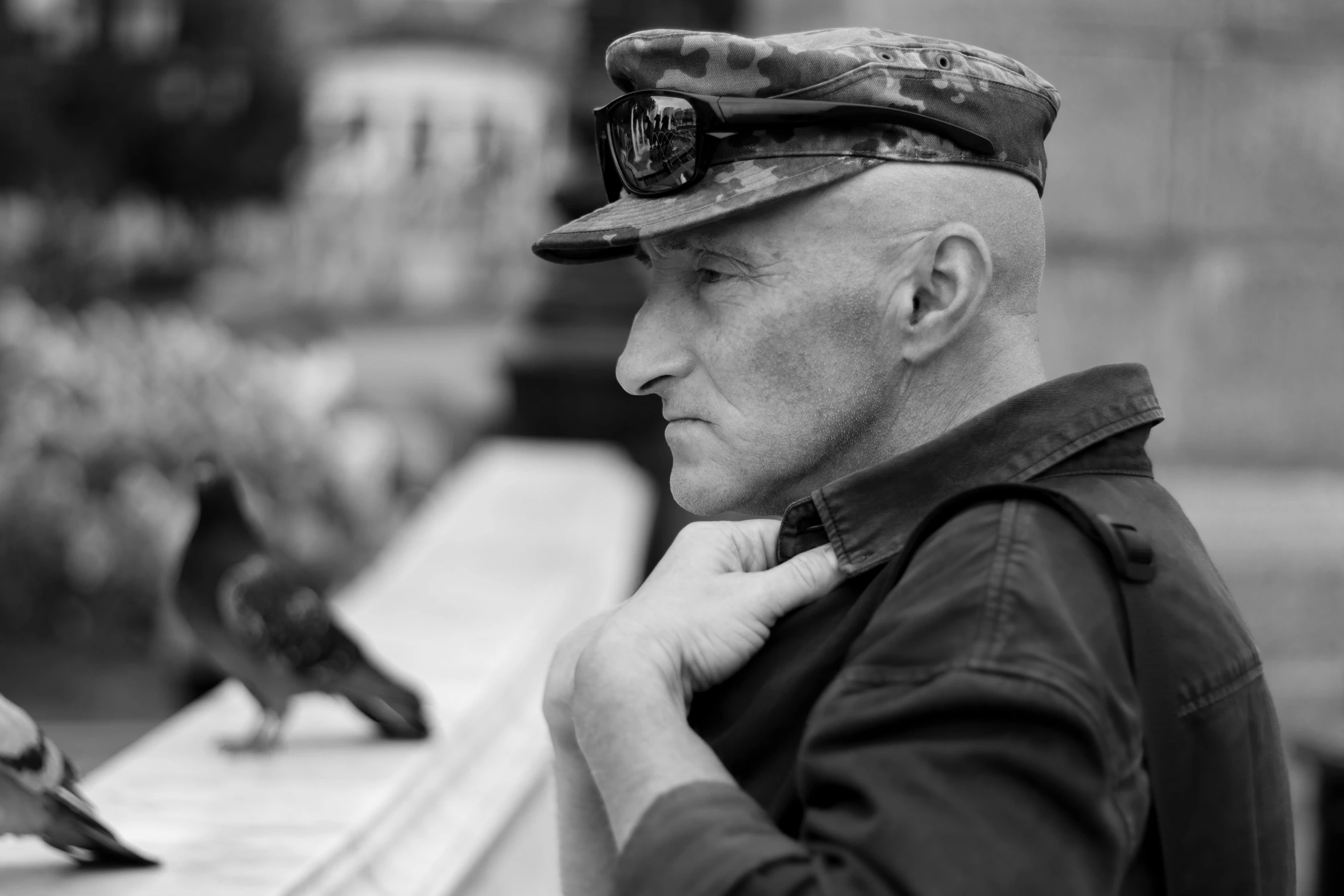 a man with sunglasses sitting on the edge of a park bench