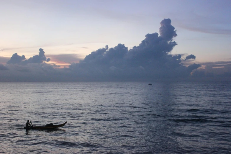 a lone canoe sitting at the end of a small body of water