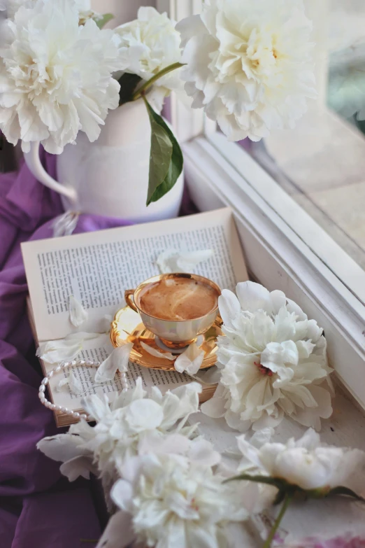 flowers in vases on window sill with an open book