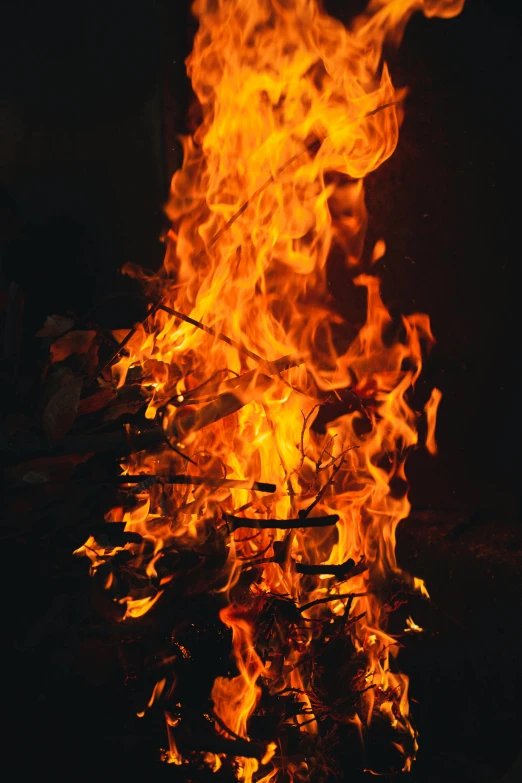 a fire burning on top of a grill next to a pile of bread