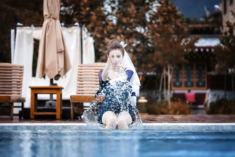 a woman kneeling in water holding an umbrella