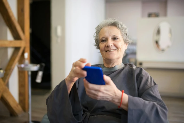 a woman smiling while looking at her cell phone