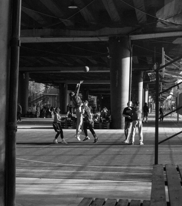 s playing with a ball under a bridge