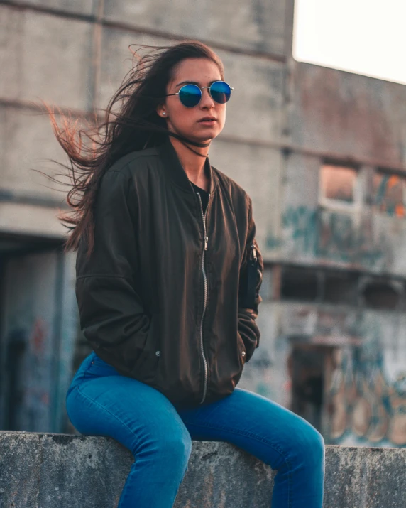 a woman posing on top of a cement wall